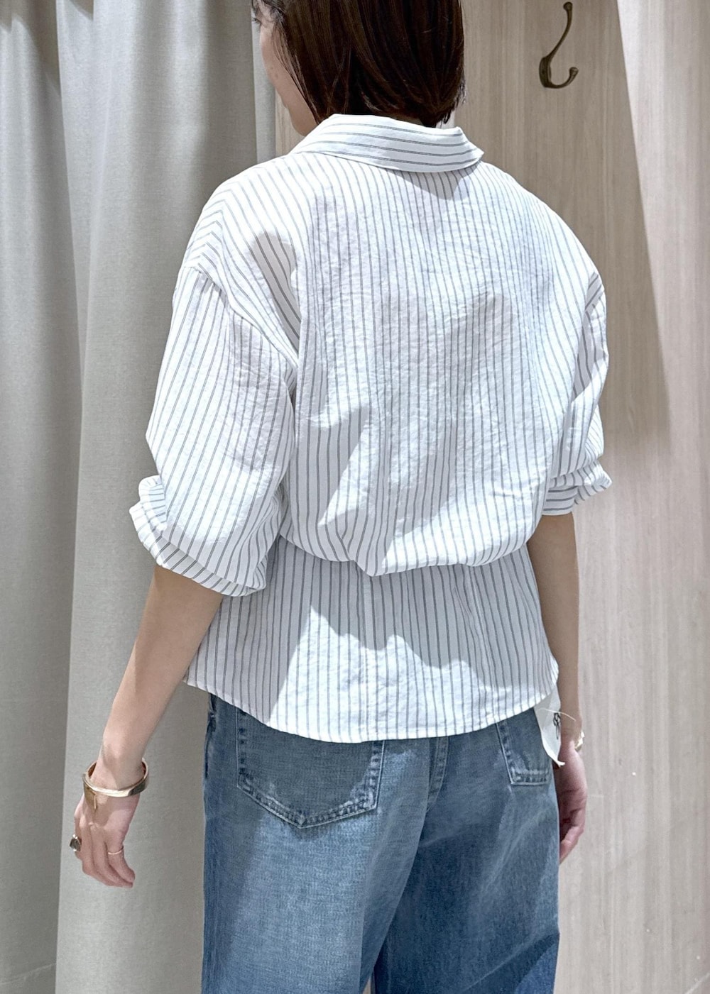 ブルー系のデニムパンツ、グリーン系のトートバッグ、ホワイト系のシャツ/ブラウスを着用したレディースの春コーディネートの8枚目の写真