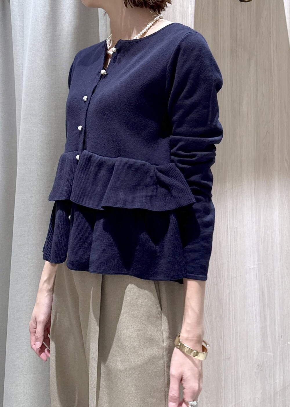 ベージュ系のスラックス、その他のハンドバッグ、ブルー系のカーディガン/ボレロを着用したレディースの冬コーディネートの9枚目の写真