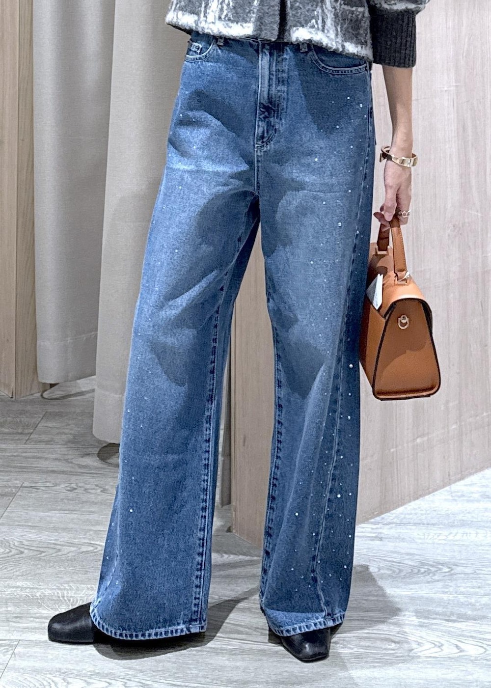 ブルー系のデニムパンツ、イエロー系のハンドバッグ、グレー系のカーディガン/ボレロを着用したレディースの冬コーディネートの9枚目の写真
