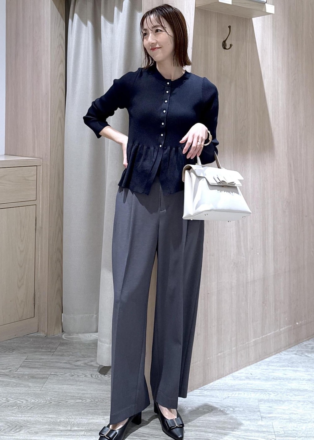 ブラック系のパンプス、グレー系のその他パンツ、ブルー系のカーディガン/ボレロを着用したレディースの冬コーディネートの10枚目の写真