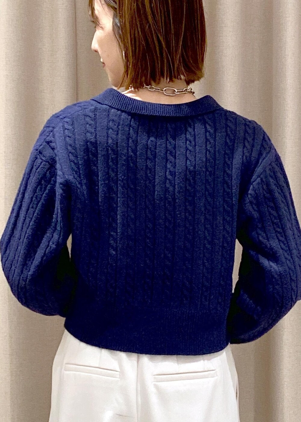 ブラック系のキャミソール、ブラック系のハンドバッグ、ホワイト系のスラックスを着用したレディースの冬コーディネートの8枚目の写真