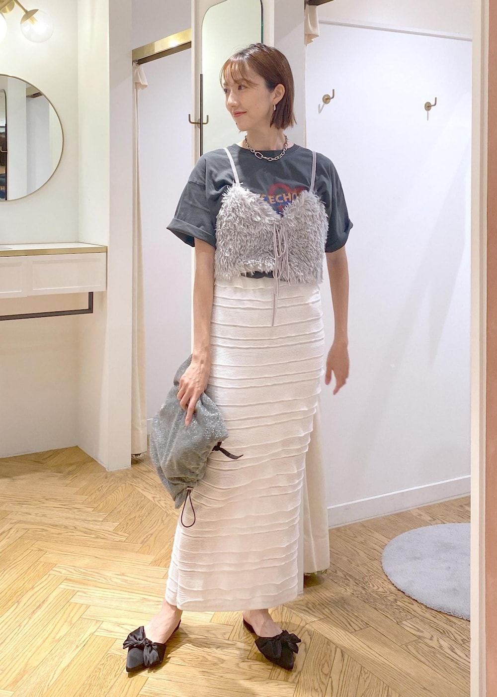 ホワイト系のスカート、シルバー系のショルダーバッグ、グレー系のキャミソールを着用したレディースの夏コーディネートの4枚目の写真
