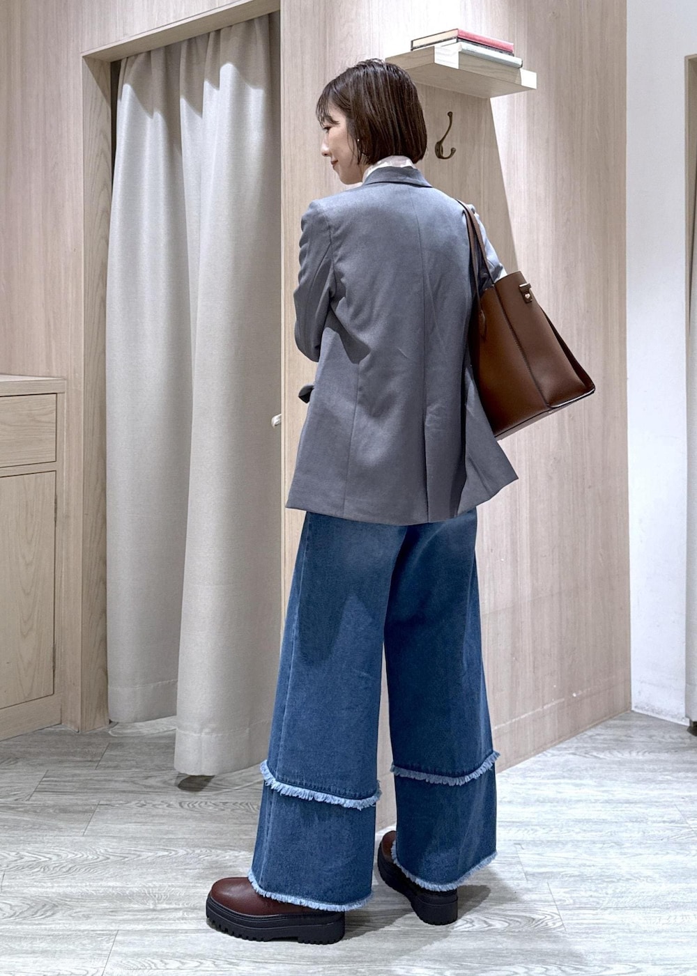 ブラウン系のブーツ、ピンク系のシャツ/ブラウス、ブルー系のデニムパンツを着用したレディースの秋コーディネートの6枚目の写真
