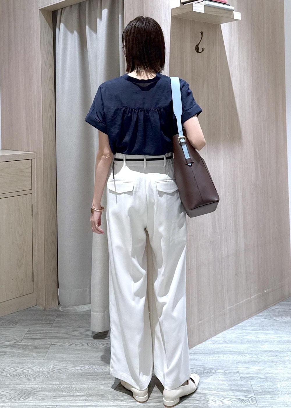 ブラウン系のトートバッグ、ホワイト系のパンプス、ブルー系のシャツ/ブラウスを着用したレディースの夏コーディネートの4枚目の写真