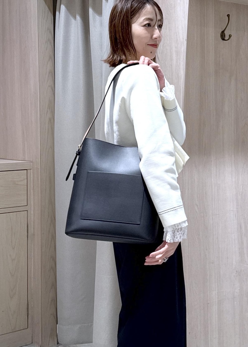 ブラック系のトートバッグ、ブルー系のその他パンツ、ブラック系のローファーを着用したレディースの冬コーディネートの5枚目の写真