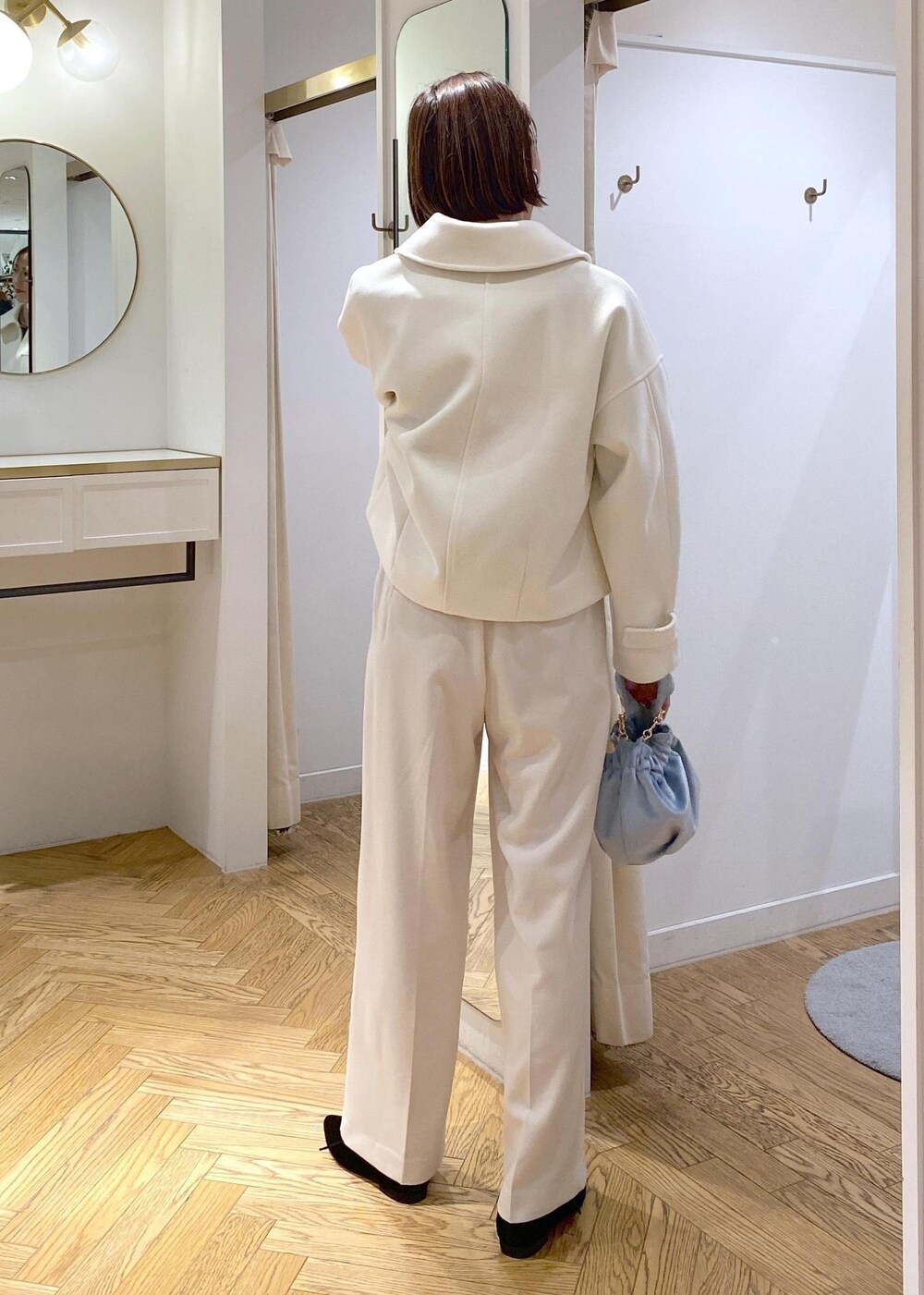 ブルー系のハンドバッグ、ホワイト系のブルゾン、ブラック系のパンプスを着用したレディースの冬コーディネートの6枚目の写真