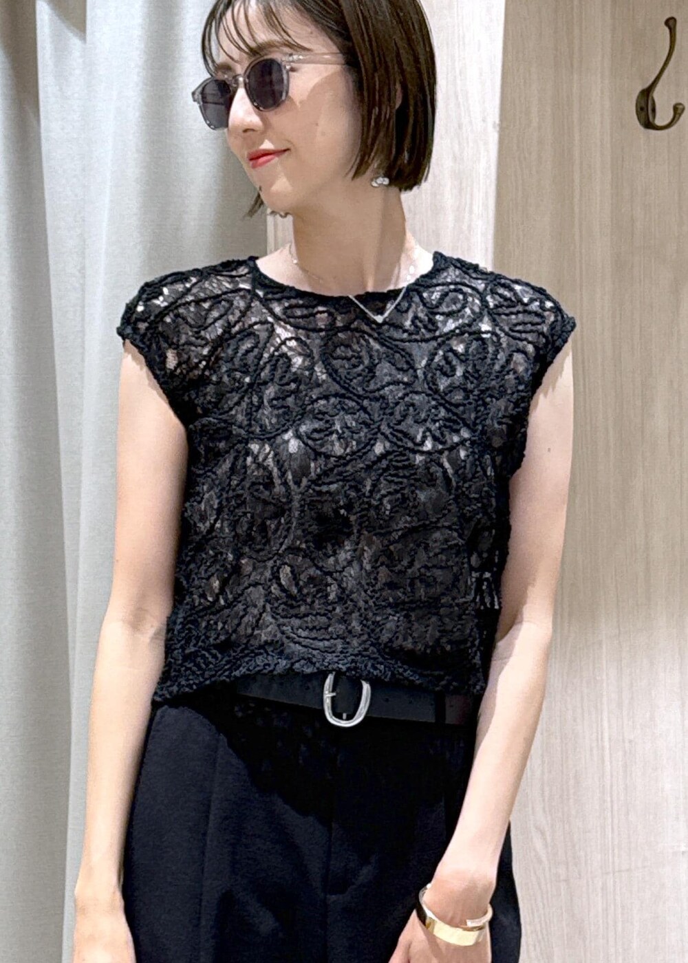 ベージュ系のキャミソール、ブラック系のサンダル、ブラック系のスラックスを着用したレディースの夏コーディネートの7枚目の写真