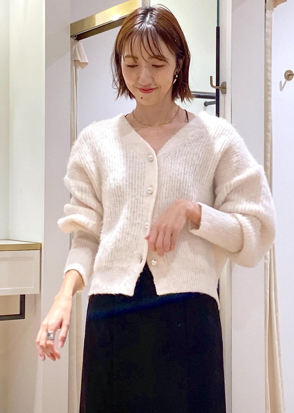 ホワイト系のブーツ、ブラック系のスカート、ブラウン系のショルダーバッグを着用したレディースの秋コーディネートの6枚目の写真