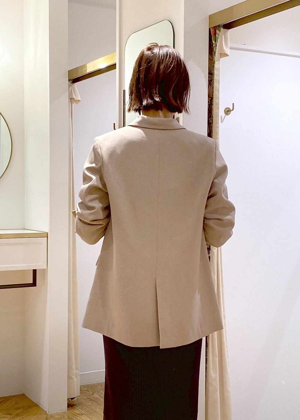 ブラック系のショルダーバッグ、ブラック系のブーツ、ベージュ系のテーラードジャケットを着用したレディースの秋コーディネートの5枚目の写真