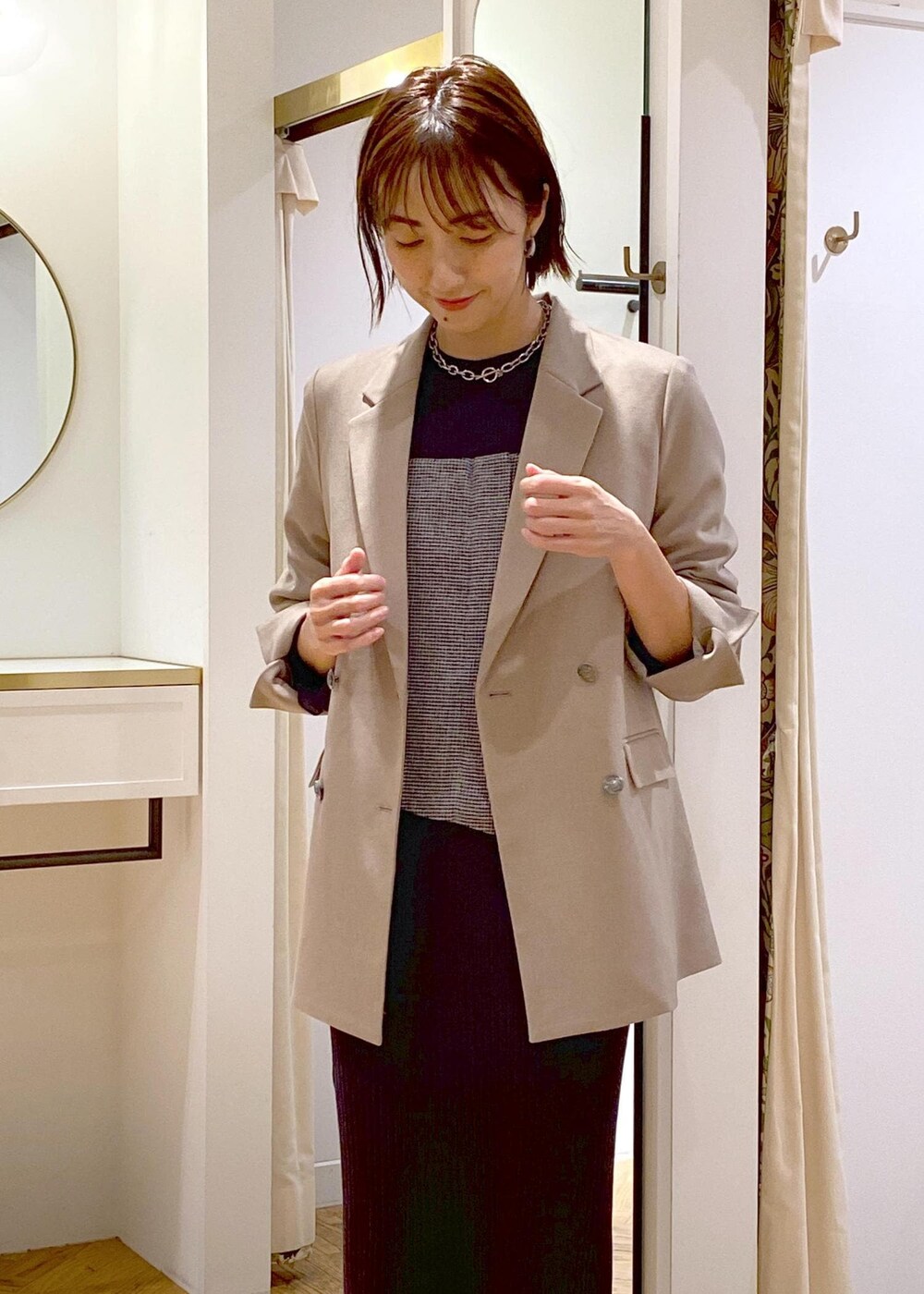 ブラック系のショルダーバッグ、ブラック系のブーツ、ベージュ系のテーラードジャケットを着用したレディースの秋コーディネートの3枚目の写真