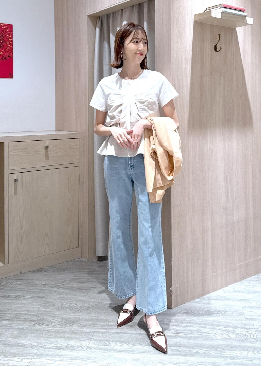 ブラウン系のパンプス、ホワイト系のTシャツ/カットソー、ブルー系のデニムパンツを着用したレディースの春コーディネートの6枚目の写真