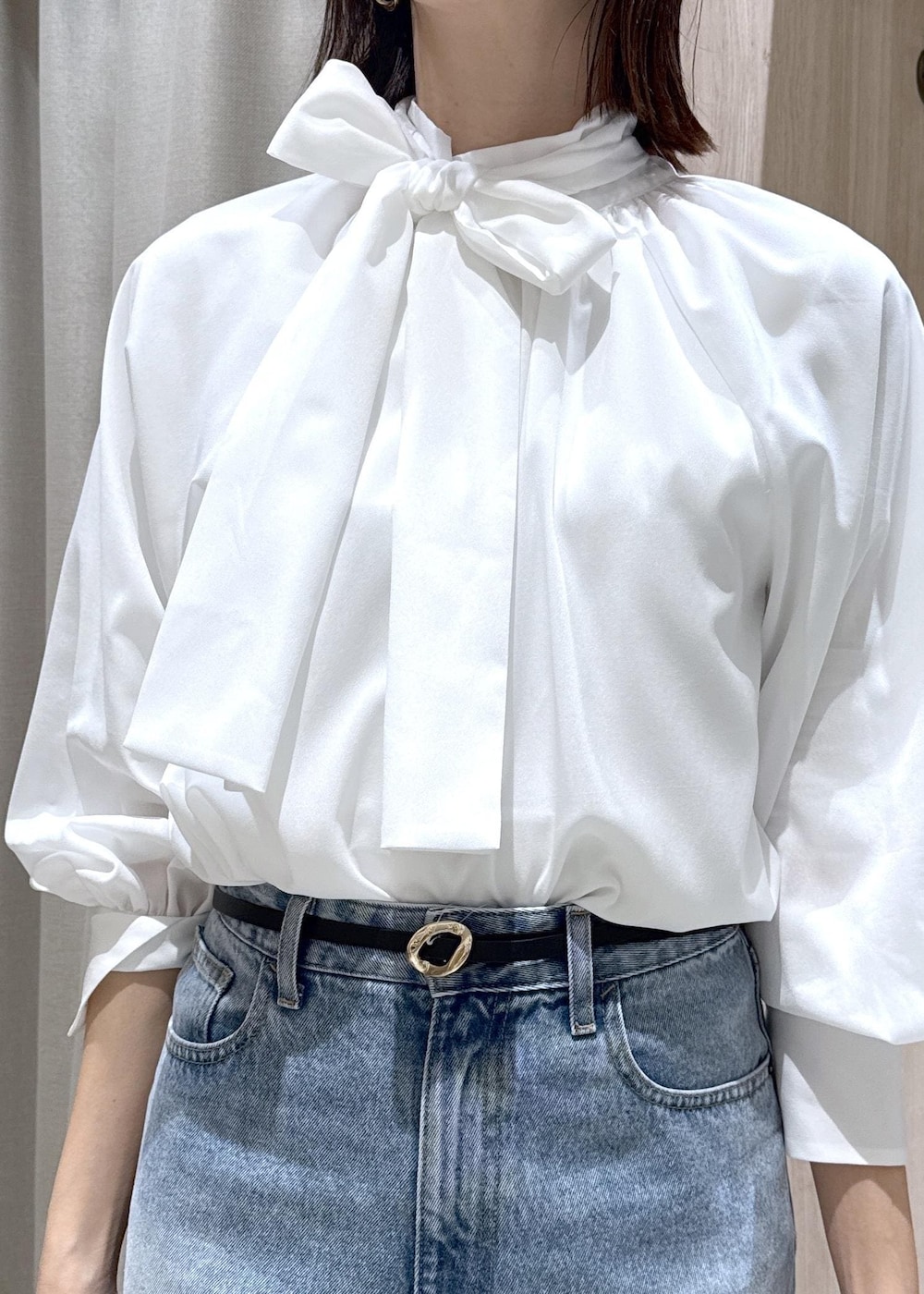 ブルー系のテーラードジャケット、ブラック系のショルダーバッグ、ブルー系のデニムパンツを着用したレディースの冬コーディネートの8枚目の写真