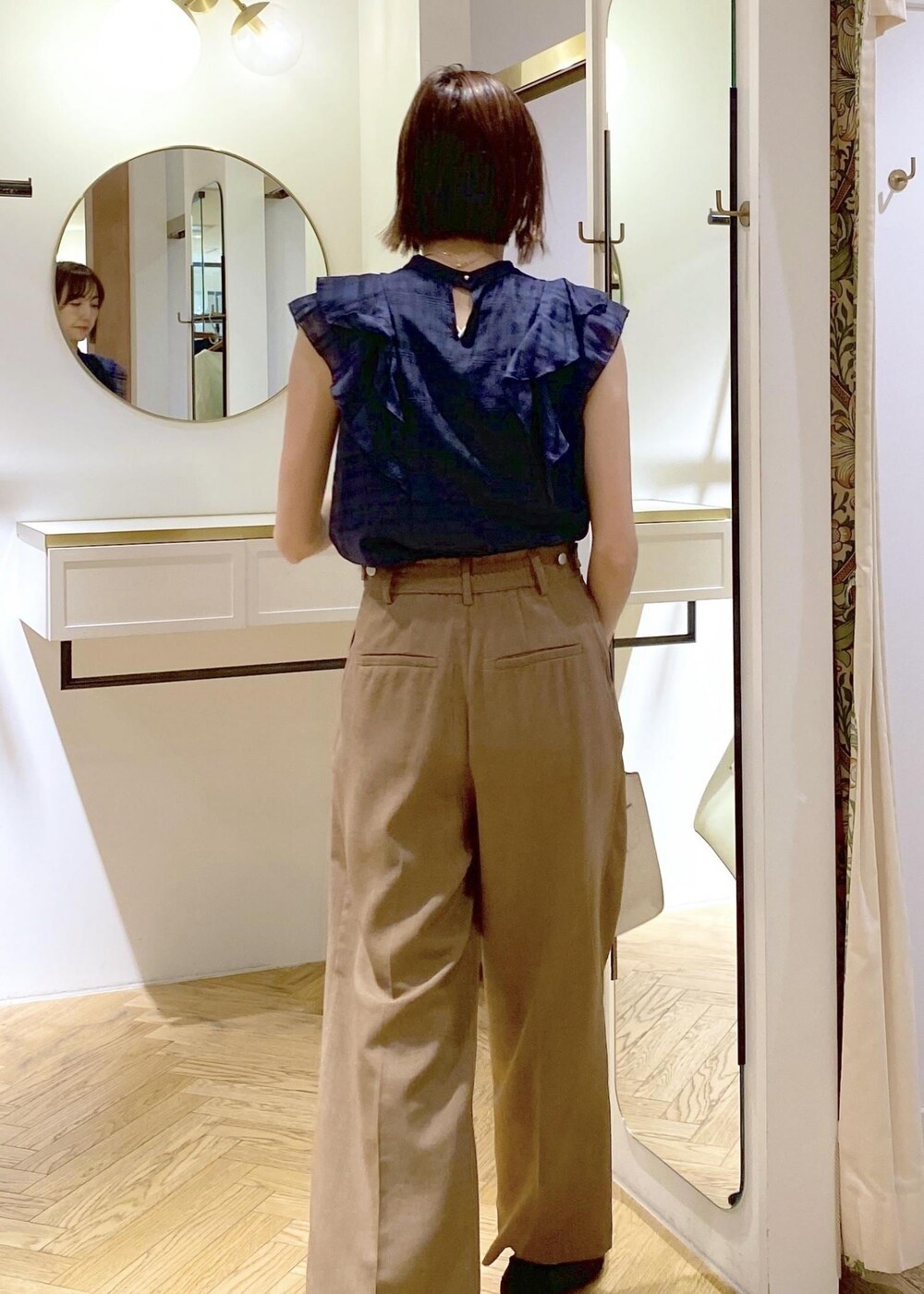 ブラック系のパンプス、ホワイト系のキャミソール、ホワイト系のハンドバッグを着用したレディースの春コーディネートの5枚目の写真