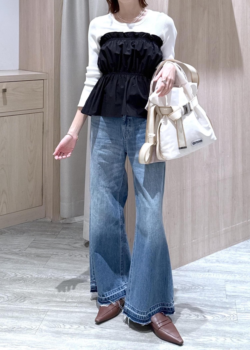 ホワイト系のトートバッグ、ブルー系のデニムパンツ、ブラック系のニット/セーターを着用したレディースの春コーディネートの10枚目の写真