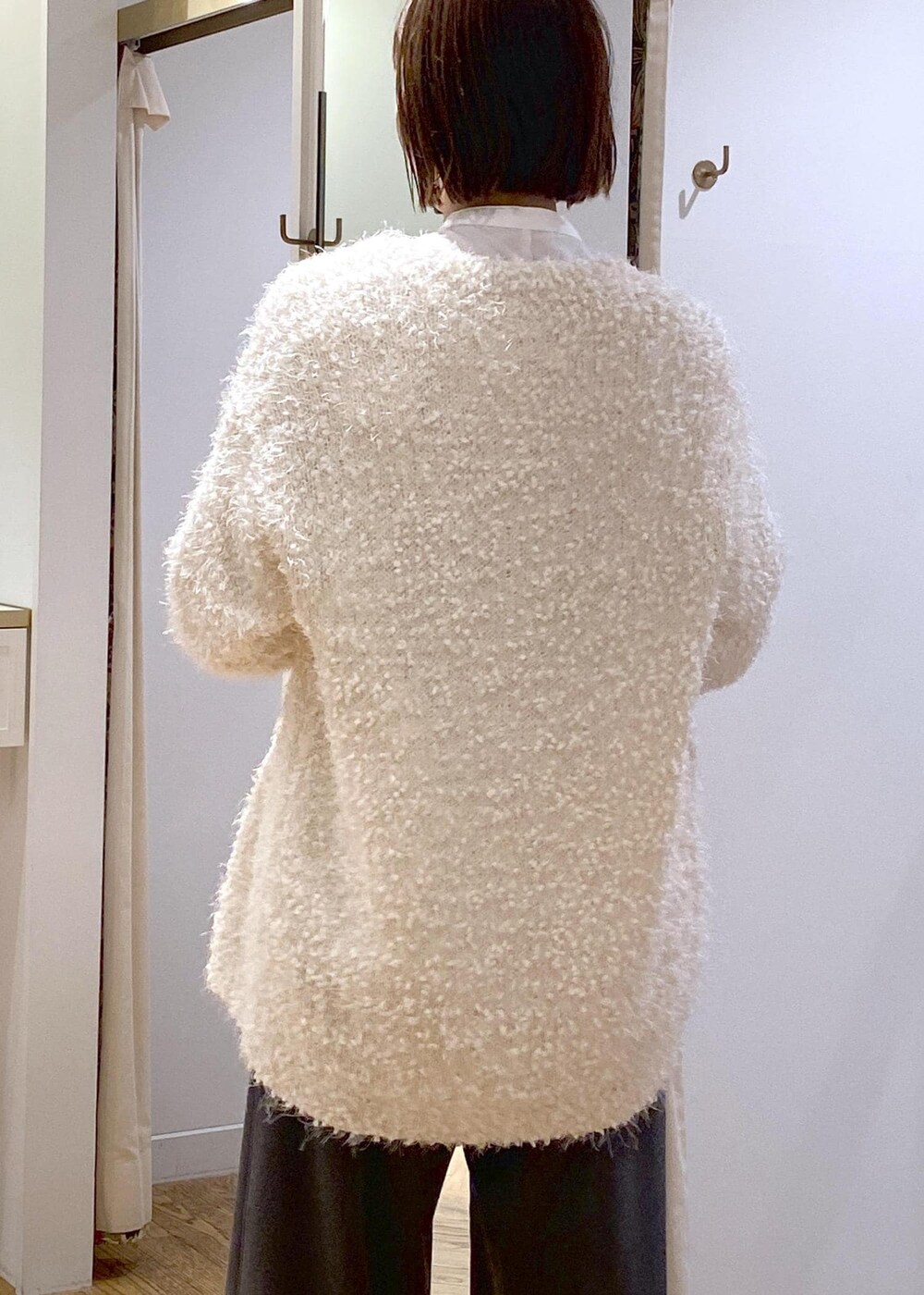 ブラック系のブーツ、ホワイト系のカーディガン/ボレロ、ホワイト系のシャツ/ブラウスを着用したレディースの冬コーディネートの7枚目の写真