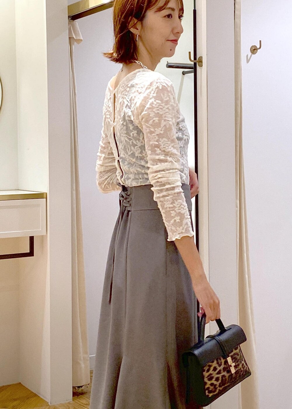 ブラック系のキャミソール、その他のショルダーバッグ、ブラック系のブーツを着用したレディースの秋コーディネートの8枚目の写真