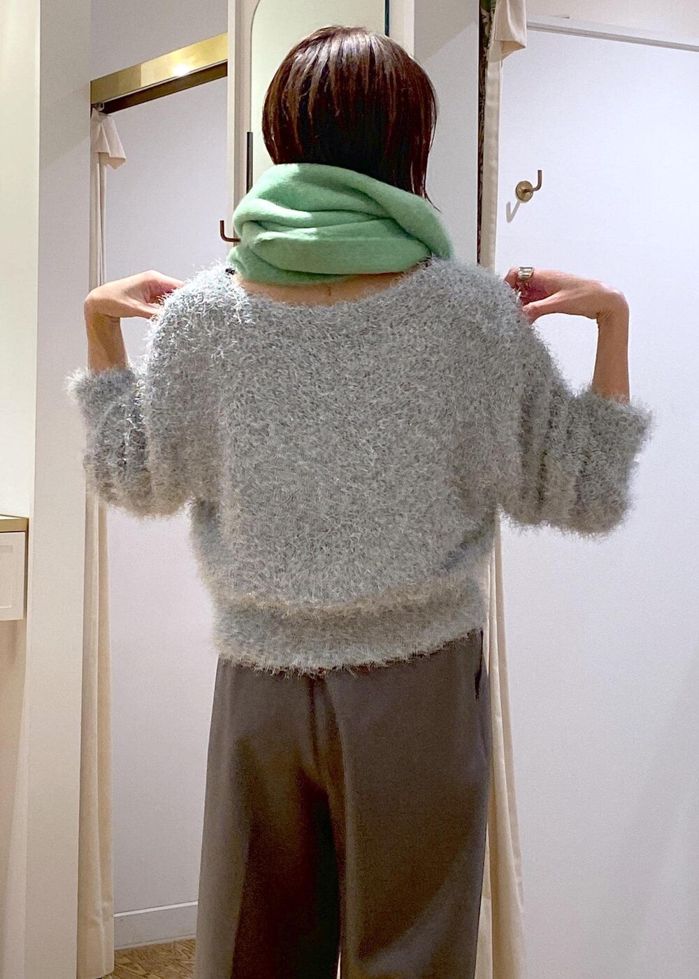 ベージュ系のショルダーバッグ、グレー系のスラックス、グリーン系のニット/セーターを着用したレディースの冬コーディネートの8枚目の写真
