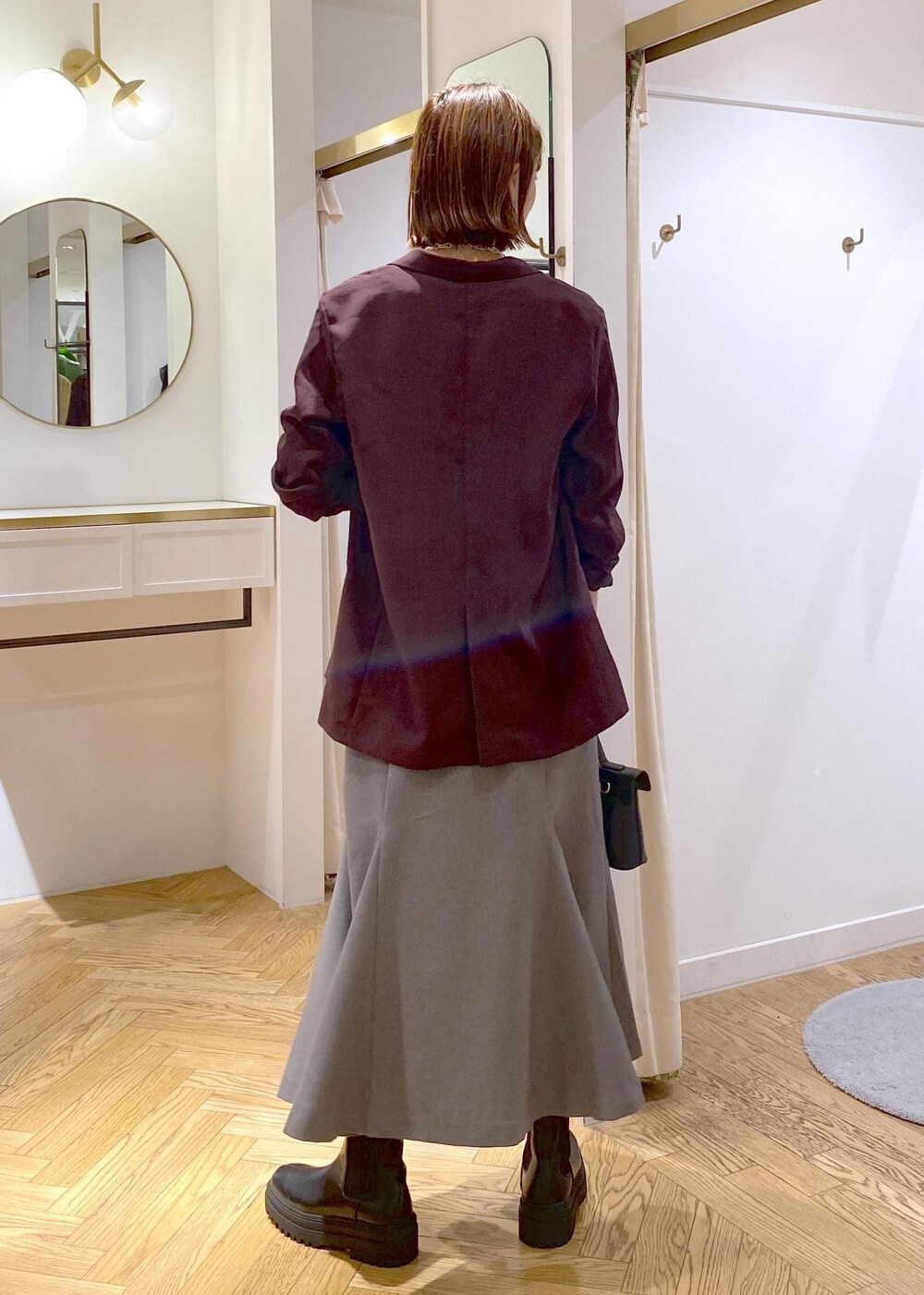 ブラック系のキャミソール、その他のショルダーバッグ、ブラック系のブーツを着用したレディースの秋コーディネートの3枚目の写真