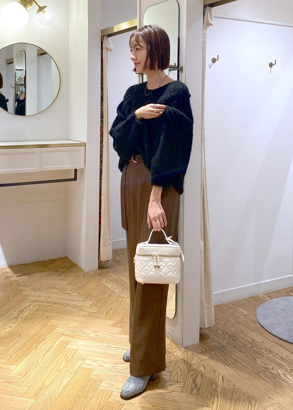 シルバー系のブーツ、ブラック系のニット/セーター、ブラウン系のその他パンツを着用したレディースの冬コーディネートの2枚目の写真