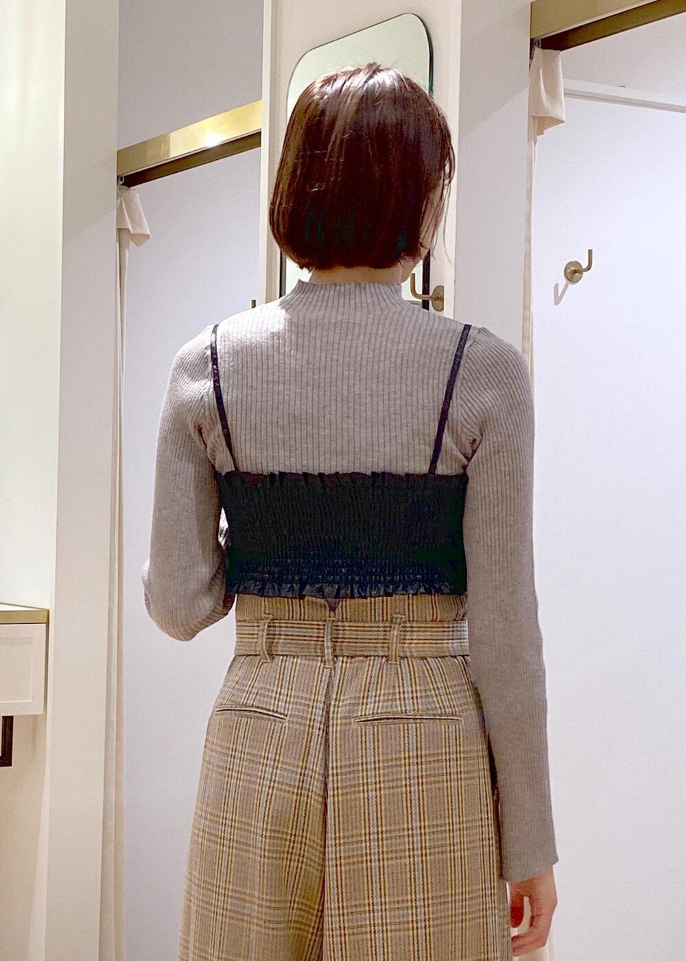 ブラック系のショルダーバッグ、ブラック系のブーツ、ベージュ系のスラックスを着用したレディースの秋コーディネートの7枚目の写真