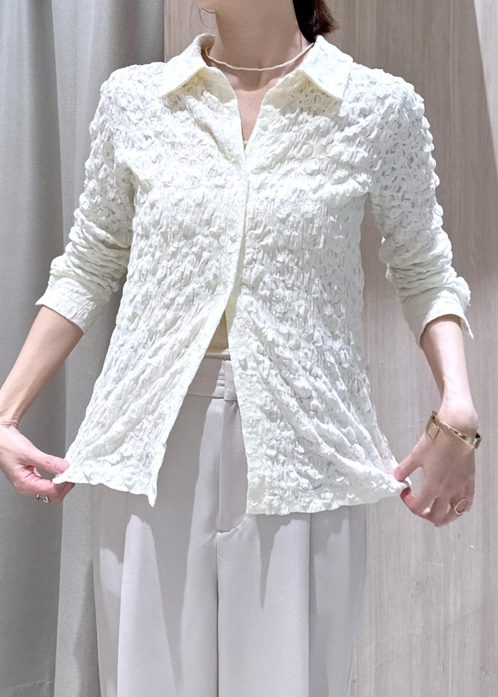 ベージュ系のその他パンツ、ホワイト系のカーディガン/ボレロ、ブラック系のショルダーバッグを着用したレディースの春コーディネートの6枚目の写真