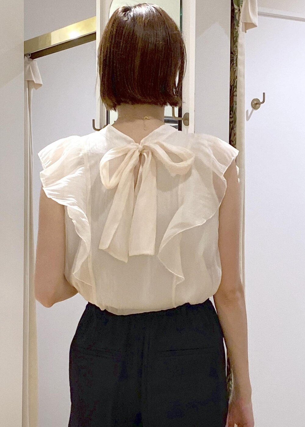 ブラック系のキャミソール、ホワイト系のショルダーバッグ、ブラック系のスラックスを着用したレディースの夏コーディネートの5枚目の写真