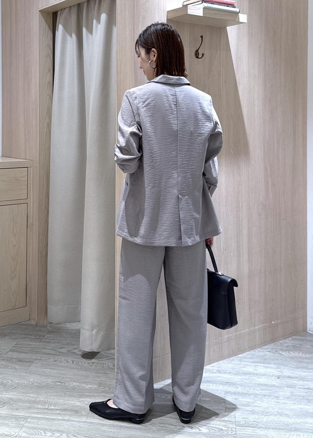 ブラック系のハンドバッグ、ブラック系のパンプス、グレー系のTシャツ/カットソーを着用したレディースの春コーディネートの3枚目の写真