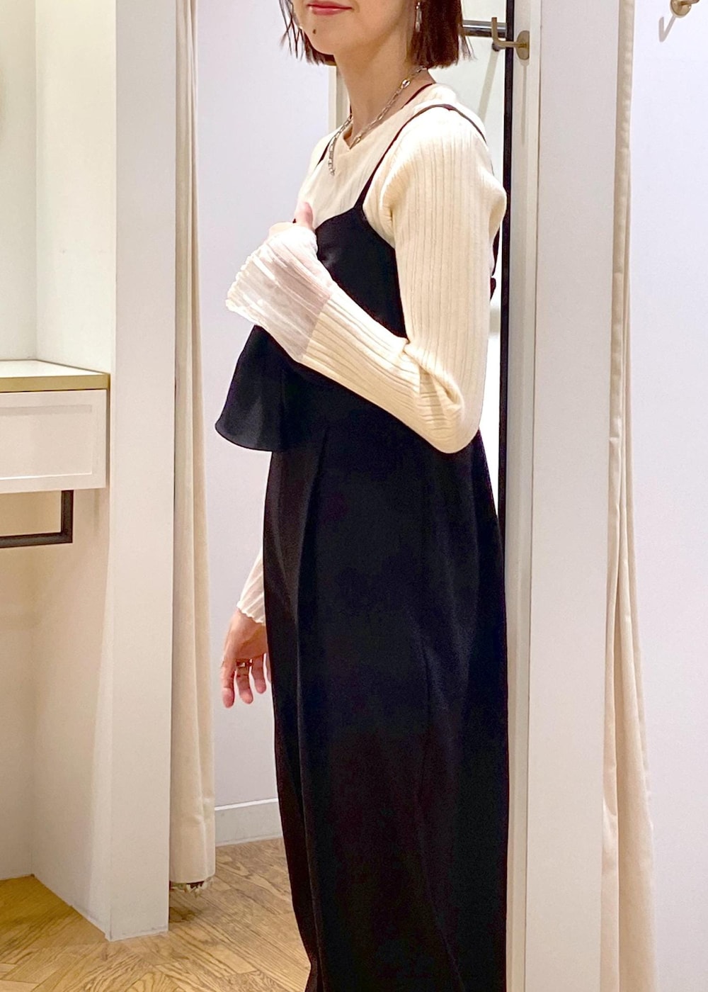 グレー系のショルダーバッグ、ブラック系のサロペット/オーバーオール、ホワイト系のニット/セーターを着用したレディースの冬コーディネートの8枚目の写真