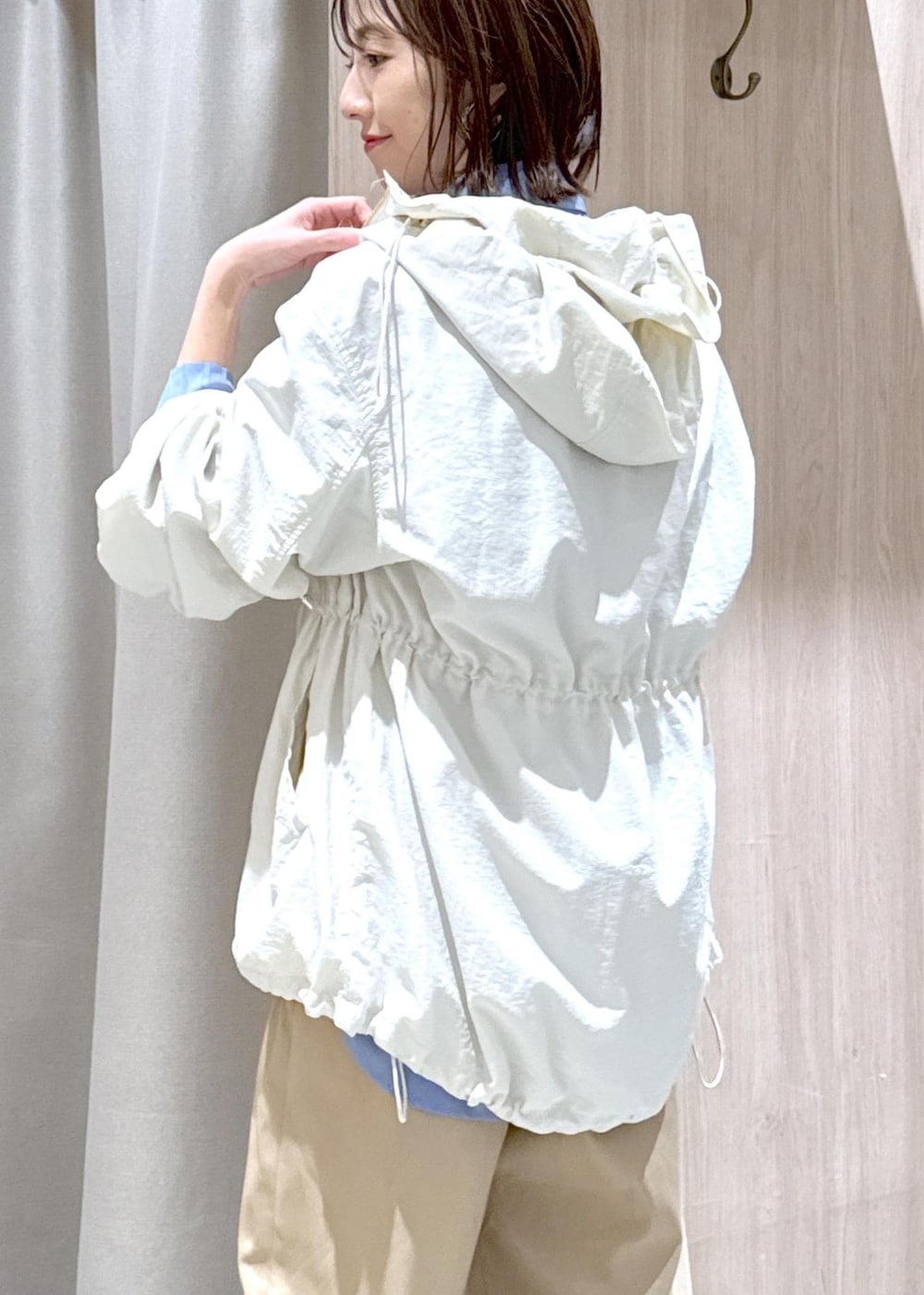 ブラック系のショルダーバッグ、ホワイト系のマウンテンパーカー、ブルー系のシャツ/ブラウスを着用したレディースの春コーディネートの9枚目の写真