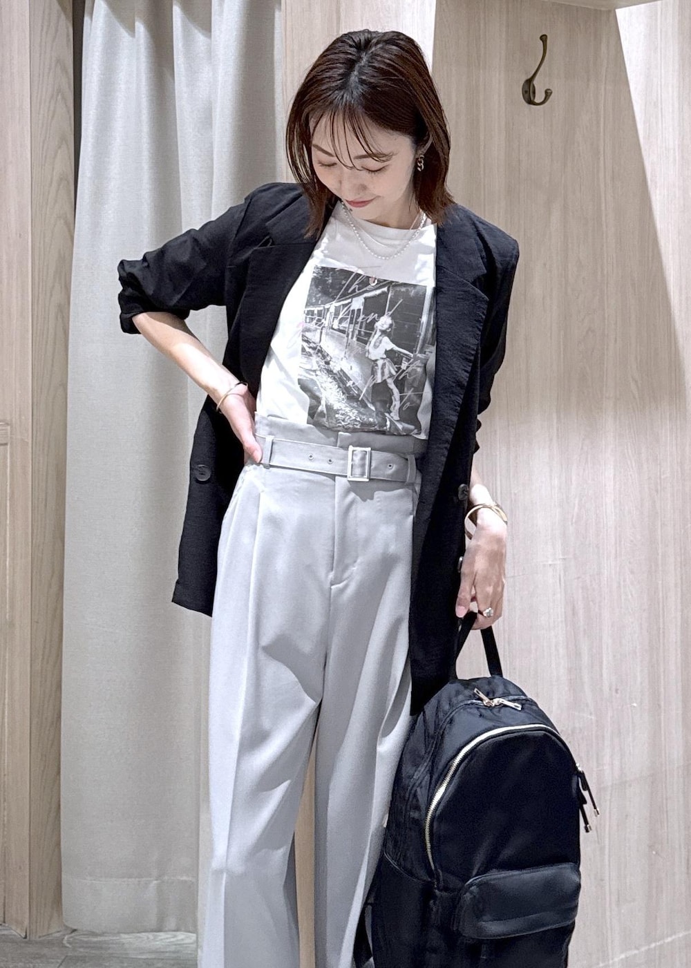 ホワイト系のTシャツ/カットソー、ブラック系のパンプス、ブラック系のバックパック/リュックを着用したレディースの春コーディネートの4枚目の写真