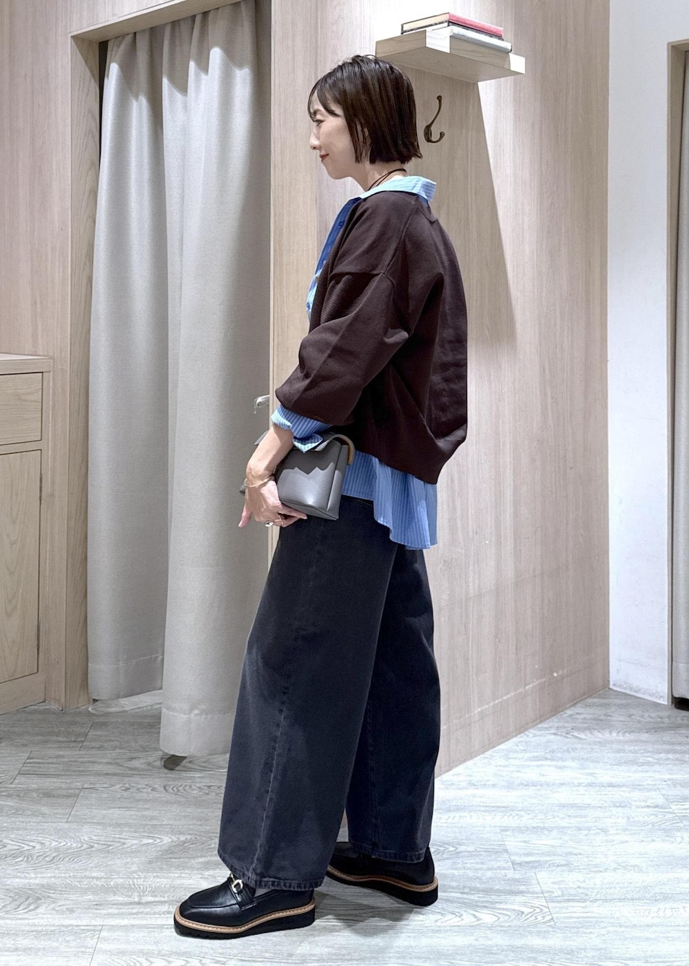 グレー系のショルダーバッグ、ブラック系のローファー、ホワイト系のキャミソールを着用したレディースの秋コーディネートの6枚目の写真