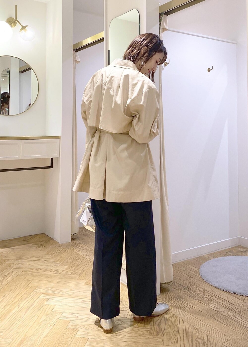 シルバー系のパンプス、ベージュ系のトレンチコート、シルバー系のハンドバッグを着用したレディースの春コーディネートの2枚目の写真