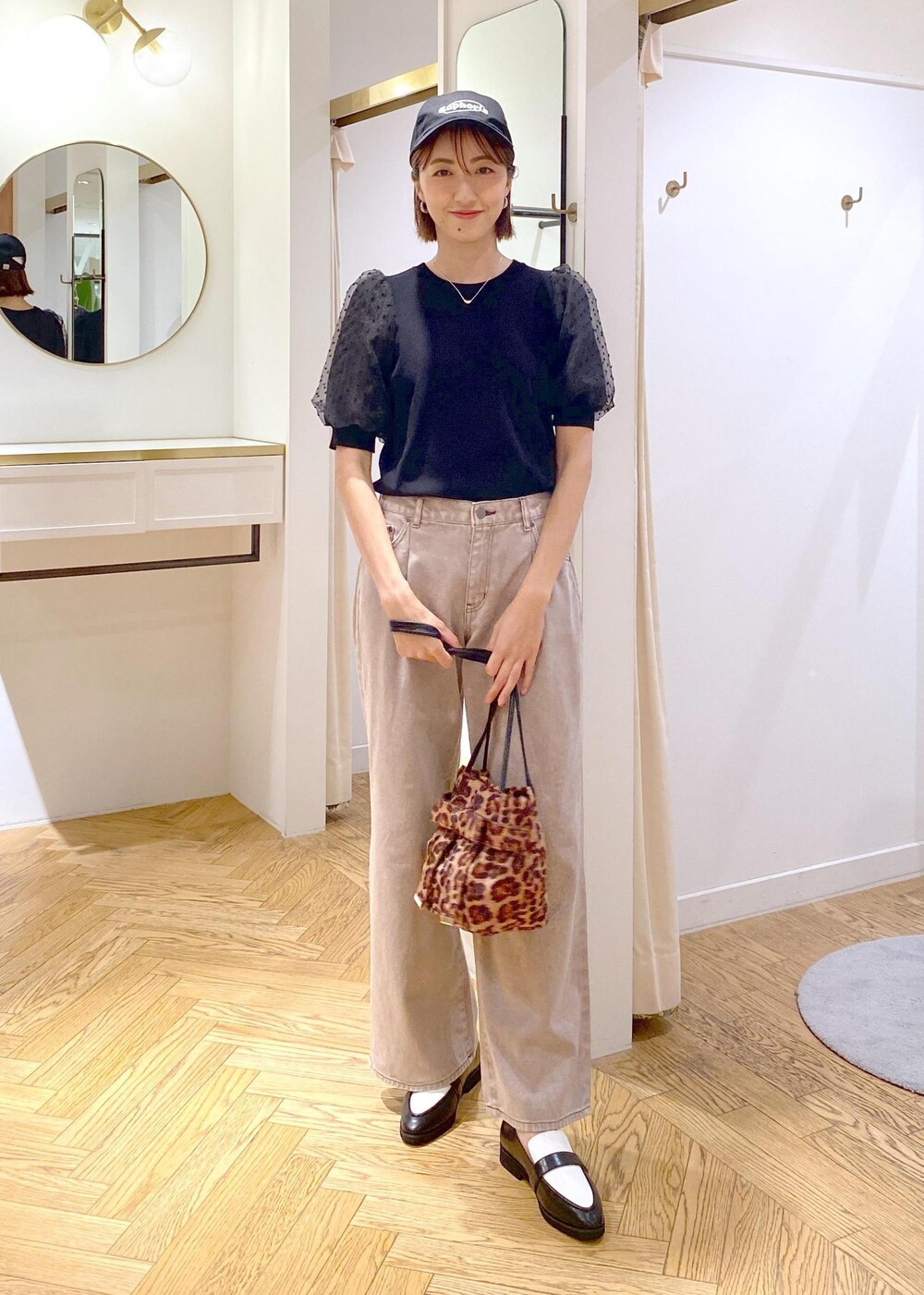 ブラック系のローファー、ブラック系のニット/セーター、ブラウン系のデニムパンツを着用したレディースの夏コーディネートの8枚目の写真