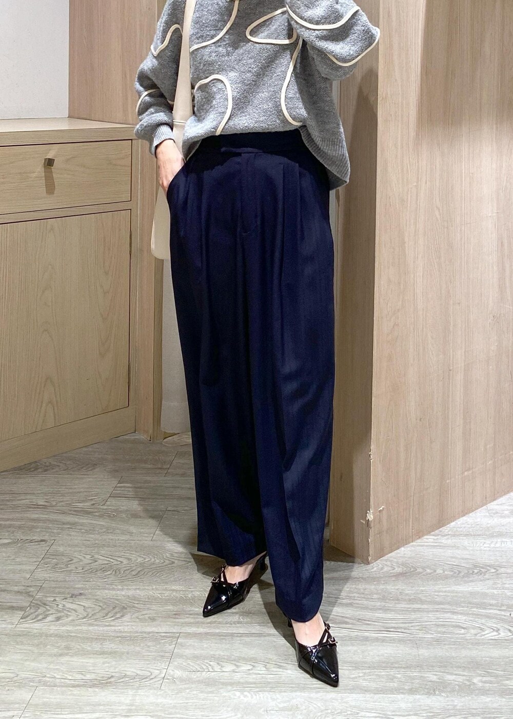 ブラック系のパンプス、グレー系のニット/セーター、ホワイト系のトートバッグを着用したレディースの冬コーディネートの6枚目の写真