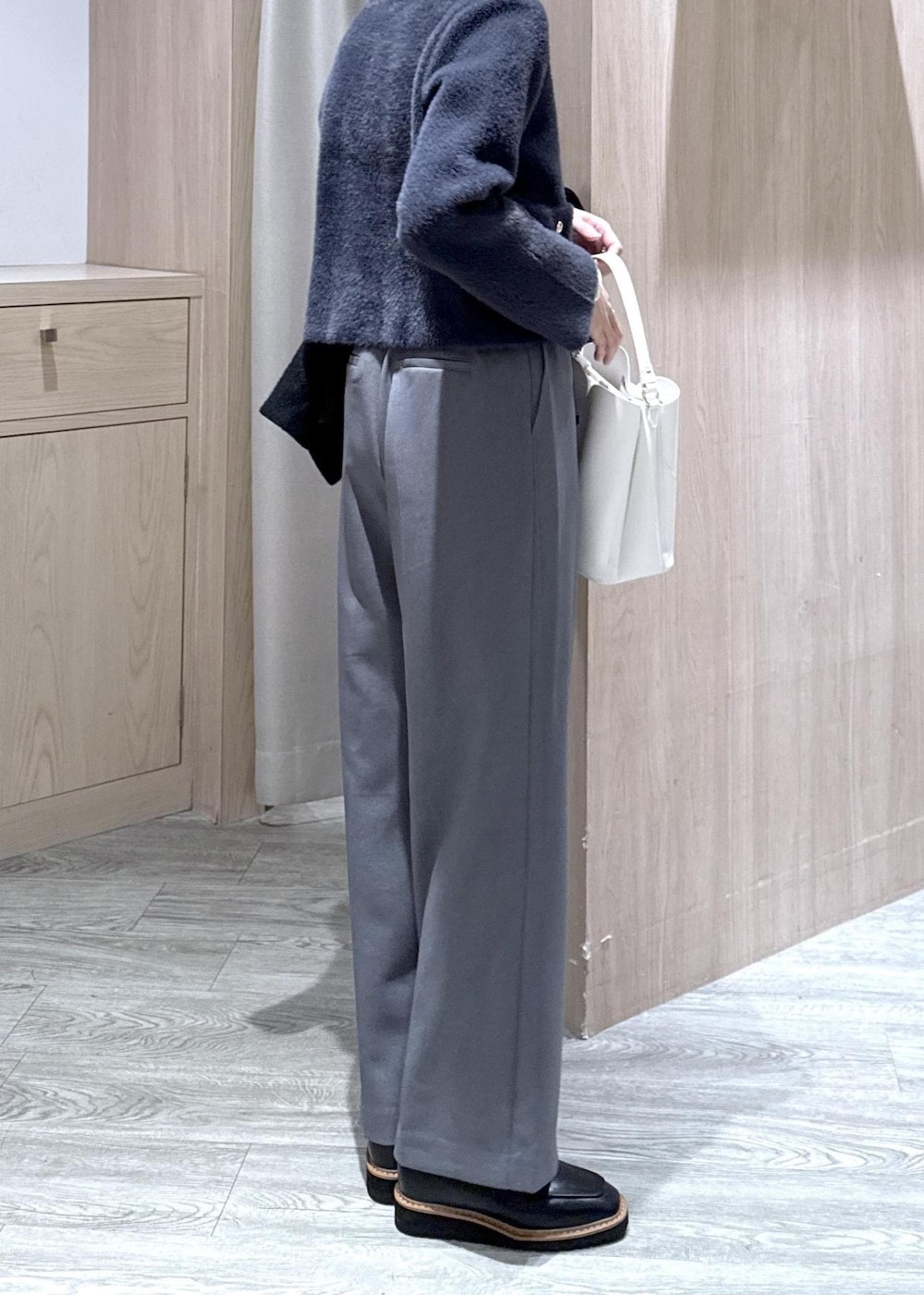 ホワイト系のショルダーバッグ、ブラック系のローファー、ブルー系のカーディガン/ボレロを着用したレディースの冬コーディネートの6枚目の写真