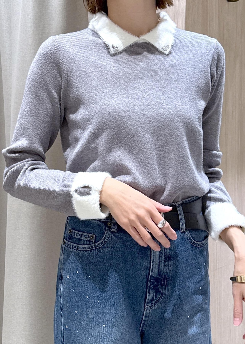 グレー系のブルゾン、グレー系のニット/セーター、ブルー系のデニムパンツを着用したレディースの冬コーディネートの7枚目の写真