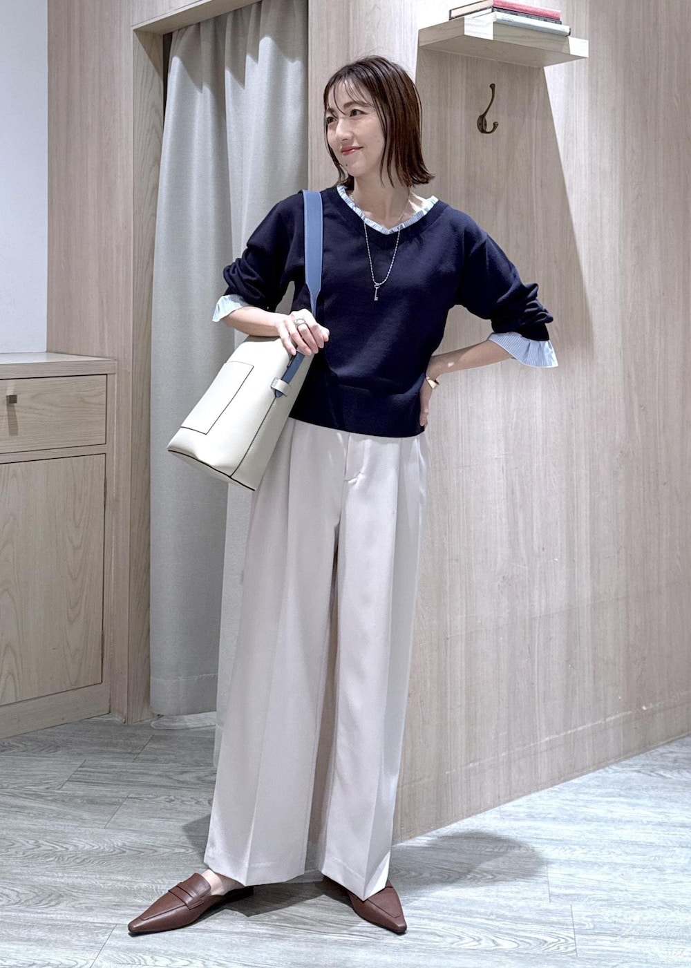 ベージュ系のトートバッグ、ベージュ系のその他パンツ、ブルー系のニット/セーターを着用したレディースの冬コーディネートの9枚目の写真