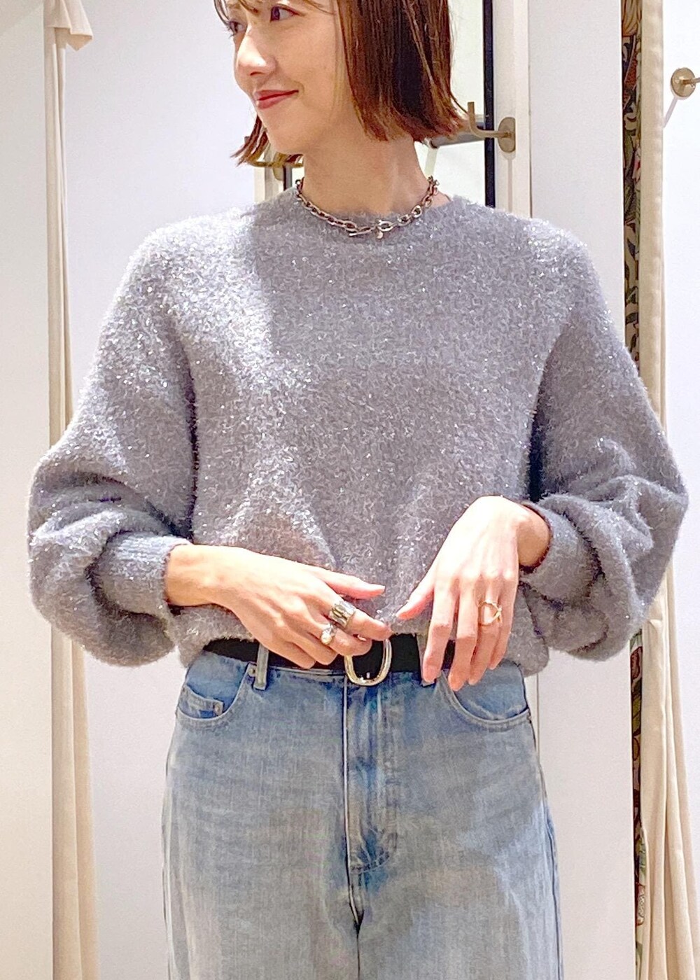 ブラック系のパンプス、グレー系のニット/セーター、ブルー系のデニムパンツを着用したレディースの冬コーディネートの8枚目の写真