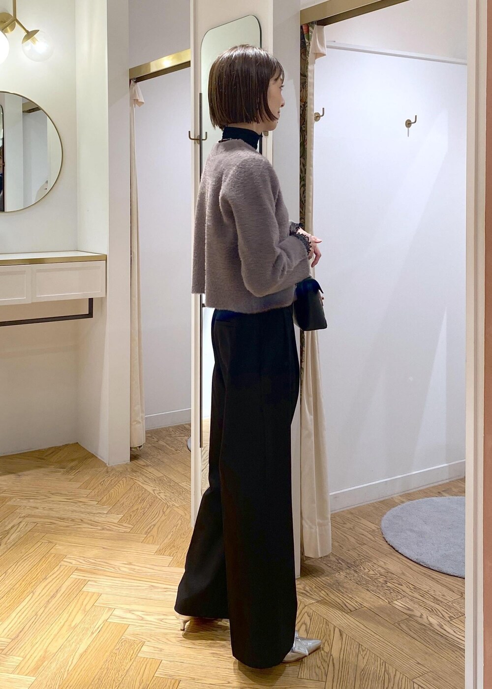 シルバー系のパンプス、ブラウン系のカーディガン/ボレロ、ブラック系のTシャツ/カットソーを着用したレディースの冬コーディネートの4枚目の写真