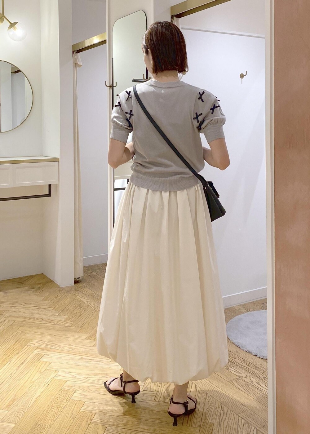 ブラック系のサンダル、ホワイト系のスカート、ブラック系のキャミソールを着用したレディースの夏コーディネートの3枚目の写真