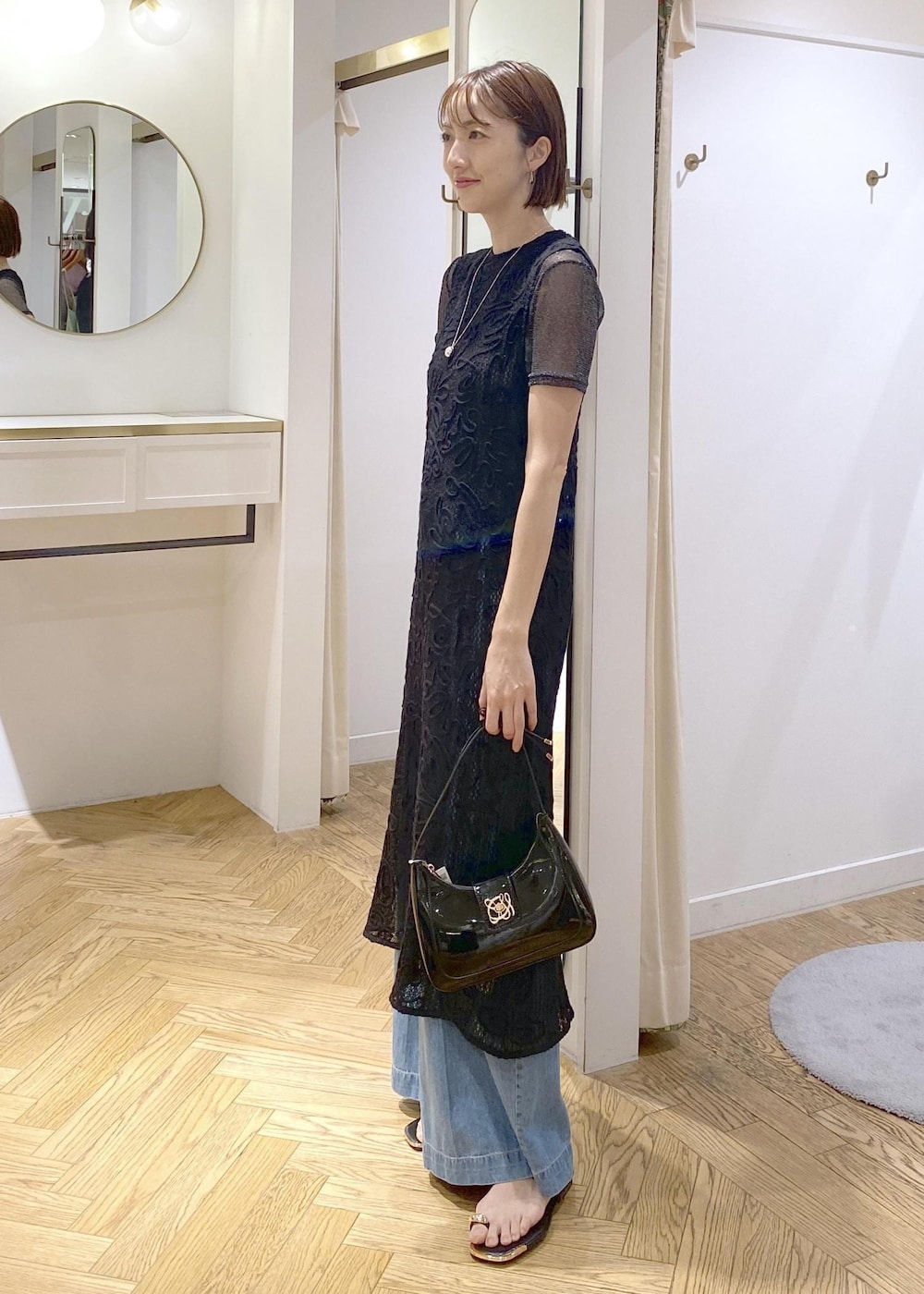 ブラック系のキャミソール、ブラック系のサンダル、ブラック系のハンドバッグを着用したレディースの夏コーディネートの2枚目の写真