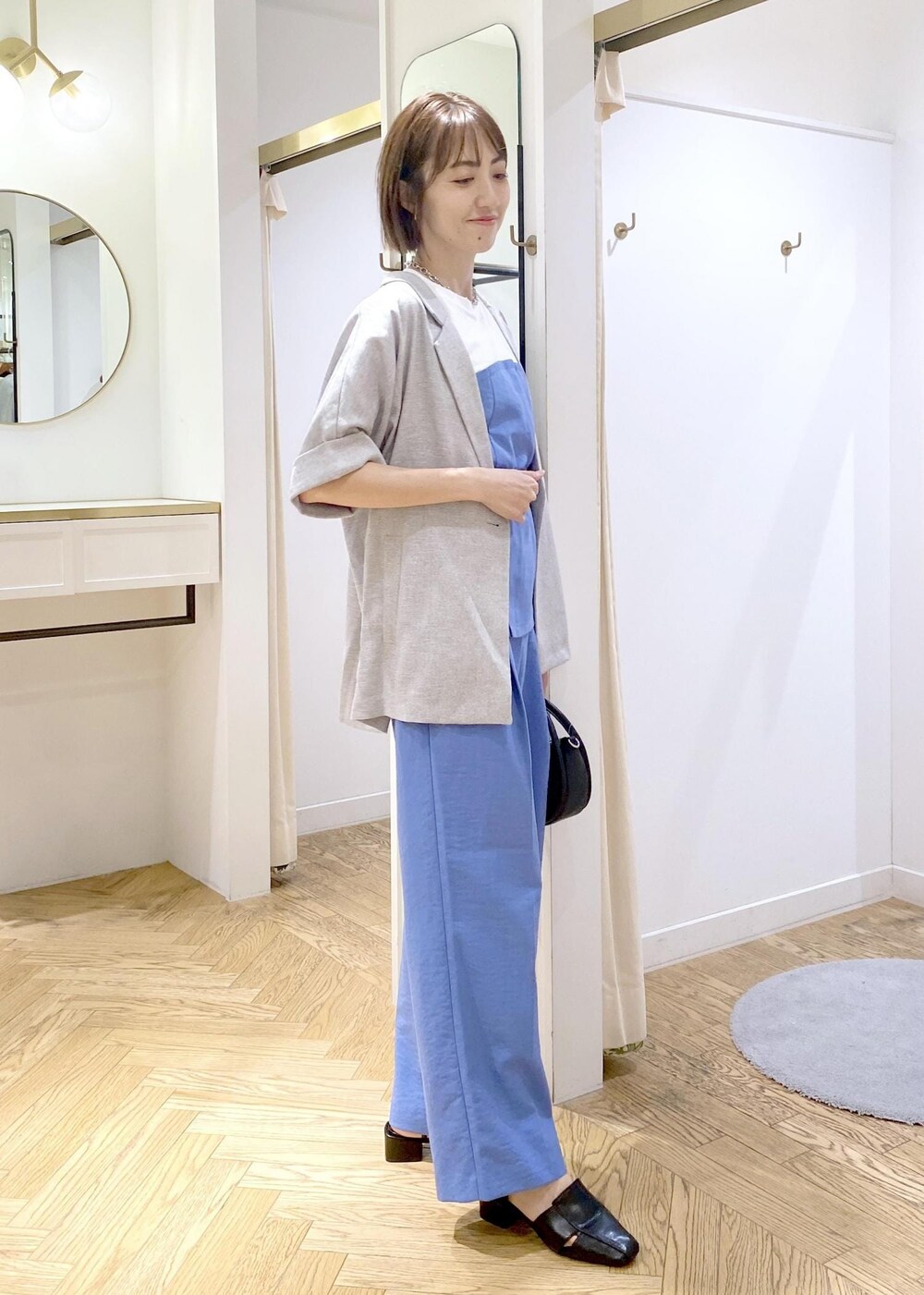 ブルー系のスラックス、ブラック系のショルダーバッグ、ブラック系のサンダルを着用したレディースの春コーディネートの5枚目の写真