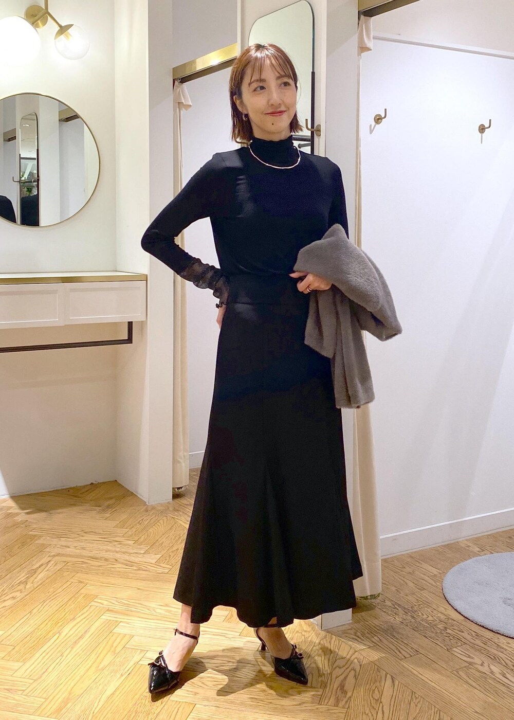ブラック系のパンプス、ブラック系のスカート、ブラウン系のその他アウターを着用したレディースの秋コーディネートの10枚目の写真
