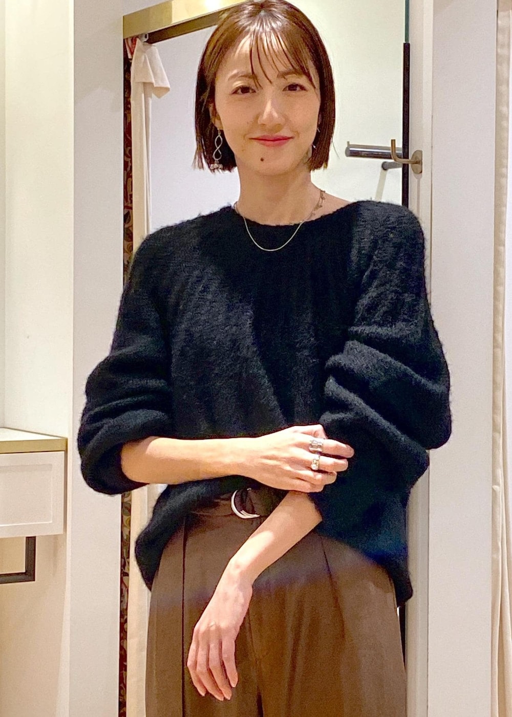 シルバー系のブーツ、ブラック系のニット/セーター、ブラウン系のその他パンツを着用したレディースの冬コーディネートの6枚目の写真