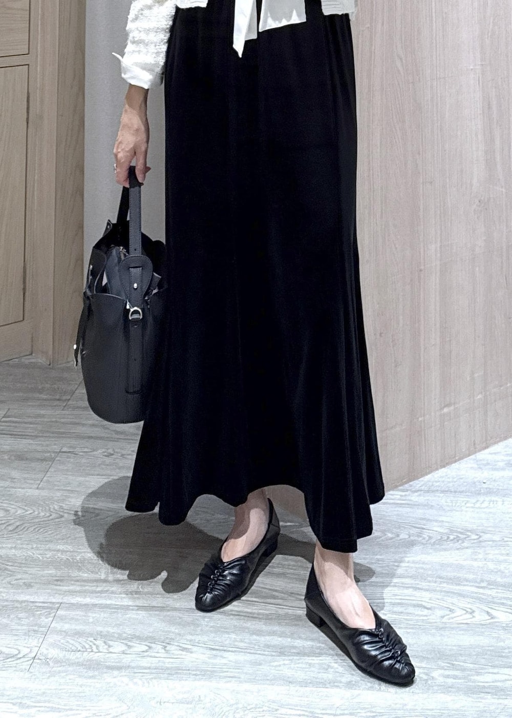 ブラック系のパンプス、ホワイト系のカーディガン/ボレロ、ブラック系のショルダーバッグを着用したレディースの秋コーディネートの9枚目の写真