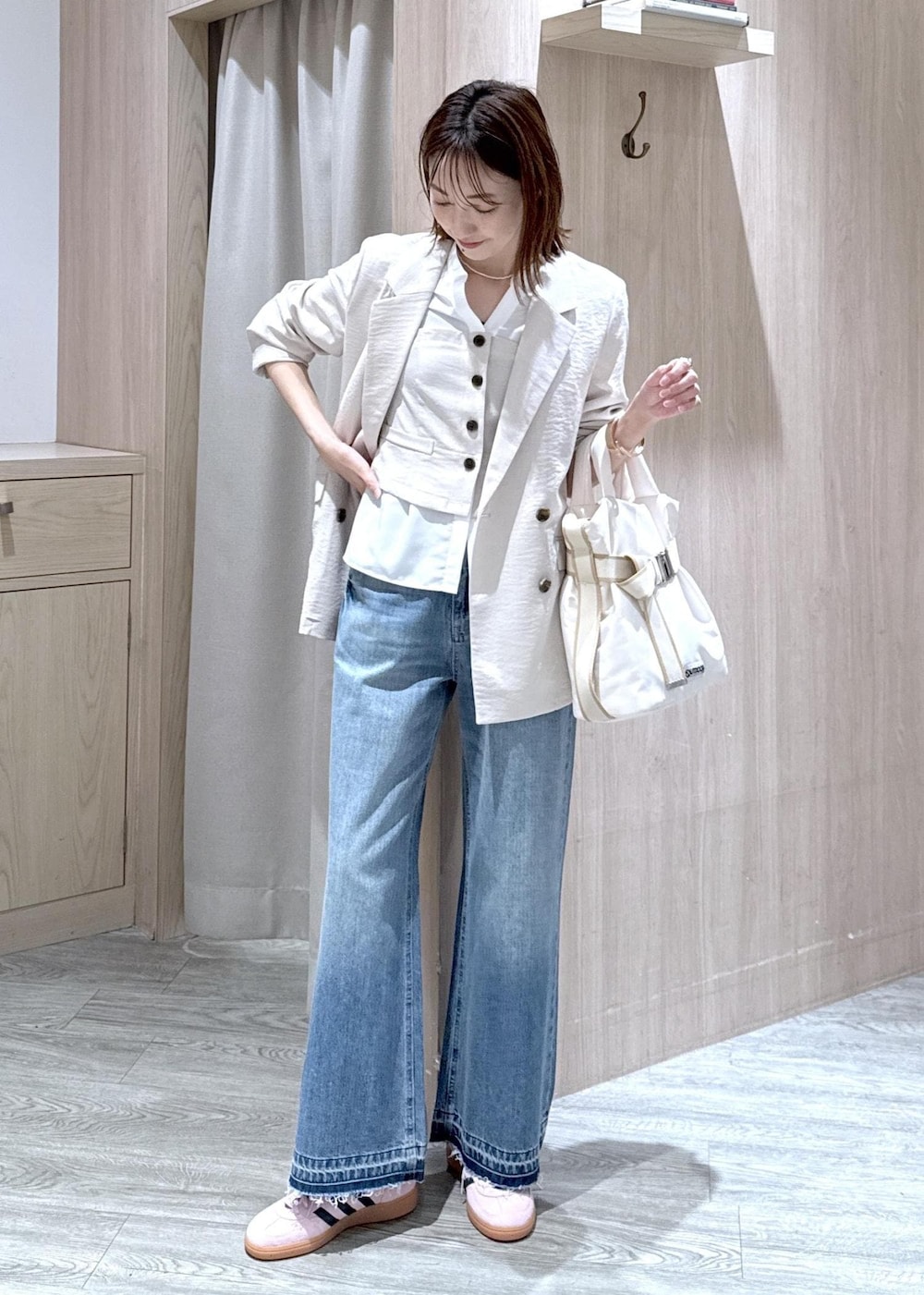 ホワイト系のトートバッグ、ブルー系のデニムパンツ、ホワイト系のシャツ/ブラウスを着用したレディースの春コーディネートの2枚目の写真
