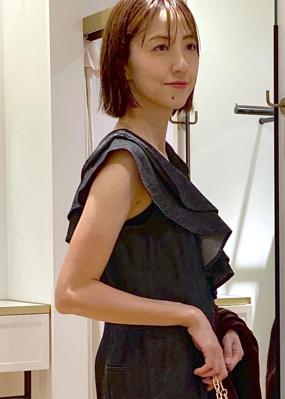 ブラック系のキャミソール、ブラック系のハンドバッグ、グレー系のドレスシューズを着用したレディースの夏コーディネートの6枚目の写真