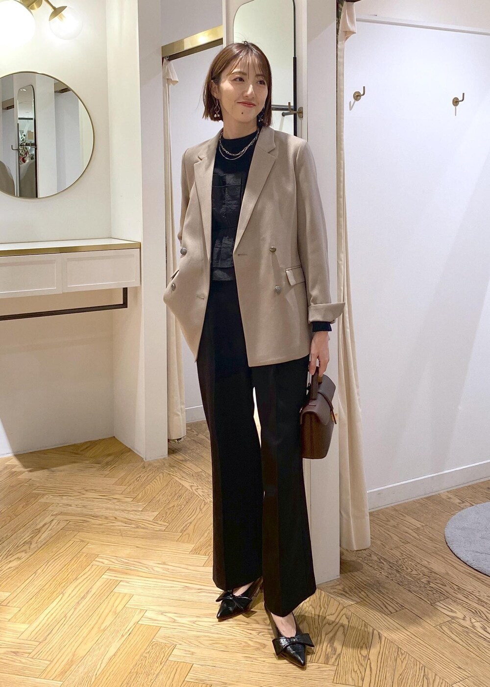 ブラック系のパンプス、ブラック系のニット/セーター、ブラック系のスラックスを着用したレディースの冬コーディネートの6枚目の写真