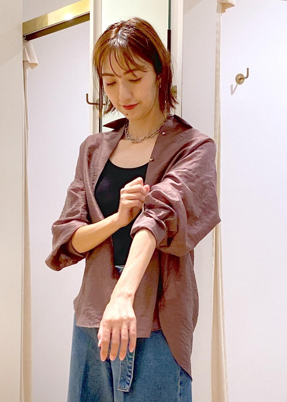 ブラック系のキャミソール、ホワイト系のショルダーバッグ、ブルー系のデニムパンツを着用したレディースの秋コーディネートの8枚目の写真