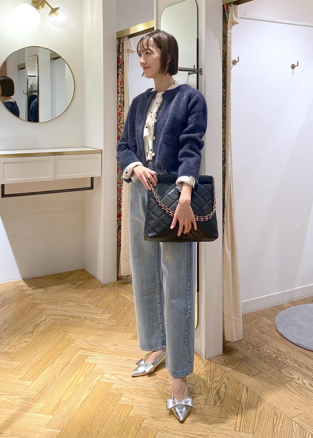 シルバー系のパンプス、ベージュ系のシャツ/ブラウス、ブルー系のカーディガン/ボレロを着用したレディースの冬コーディネートの5枚目の写真